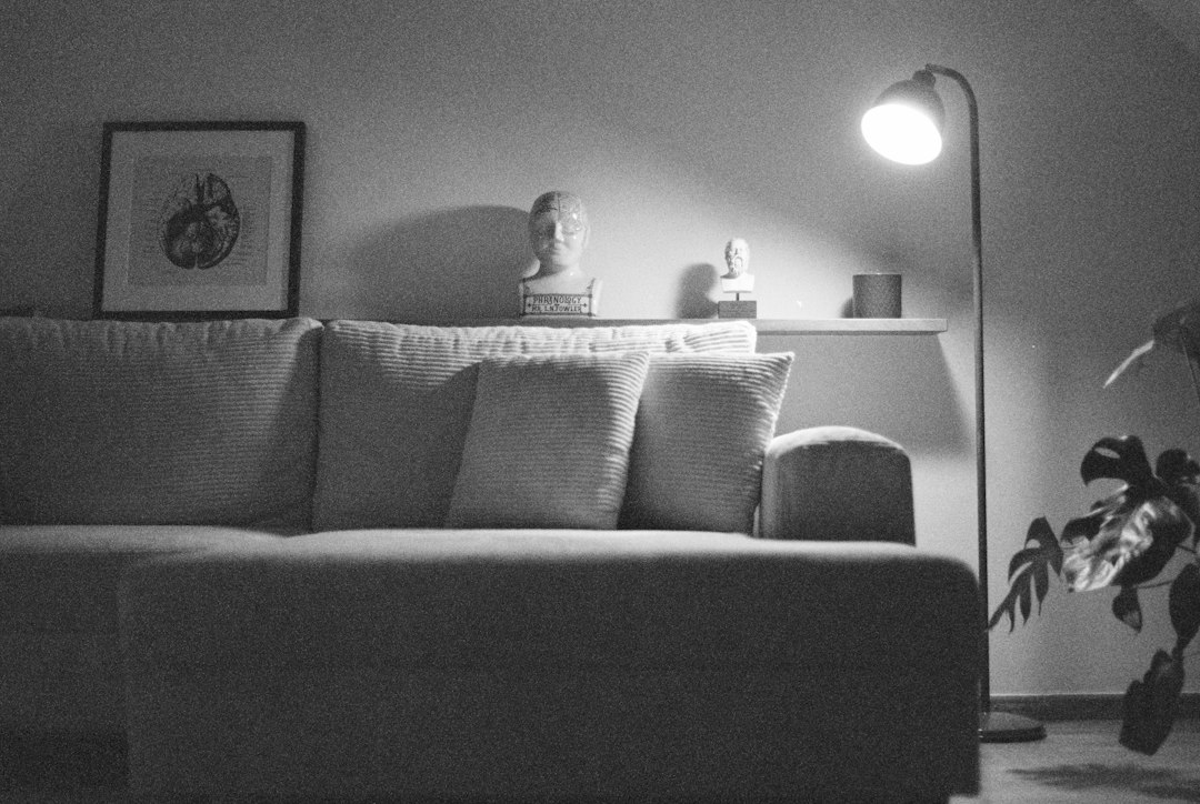 A dimly lit living room with a sofa and lamp
